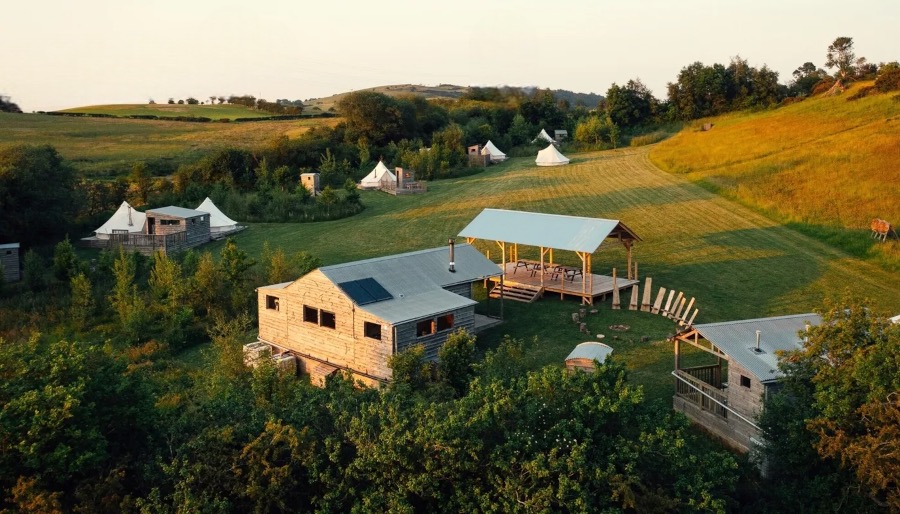 The Forge site — bell tents, timber cabins and a covered deck in the North Wales countryside